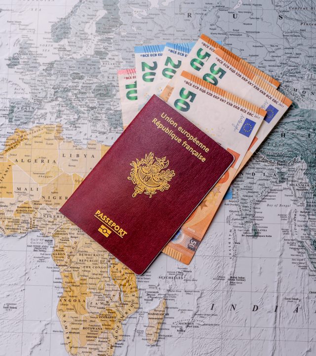 conceptual background for travel with passport, magnifying glass, world map and money